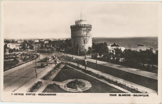 3225kart | Ο Λευκός Πύργος ενώ αριστερά διακρίνουμε το τραμ της πόλης το οποίο λειτουργούσε έως το 1957. | Θεσσαλονίκη | T128/019
